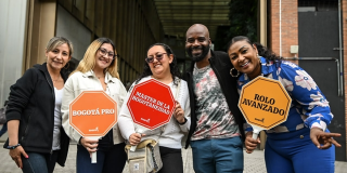 Foto de grupo de personas con carteles llamativos en torno a los diferentes gentilicios de los habitantes de Bogotá. 