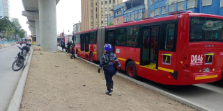 Foto de un bus de TransMilenio y un agente de tránsito en una vía de Bogotá 