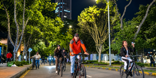 Imagen de varias personas transitando por una vía de Bogotá en su bicileta en la ciclovía nocturna.