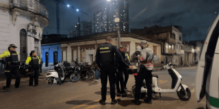 Foto de Gestores del Orden y policías verificando una moto eléctrica robada.