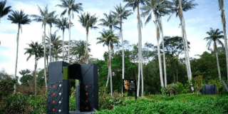Escultura de Edgar Negret es exhibida en las instalaciones del Jardín Botánico de Bogotá entre zonas verdes, corredores con vegetación y palmas de gran altura.
