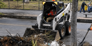 Foto que muestra un tractor recolectando basuras 