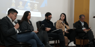 Foto que muestra personas sentadas en una tarima 