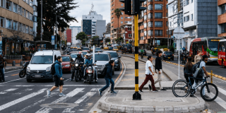 Foto que muestra carros y personas caminando por la calle