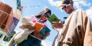 Imagen de un hombre y una mujer que miran cada uno un libro que tienen en sus manos.