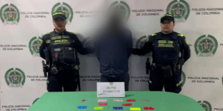 Hombre capturado en medio de dos policías.
