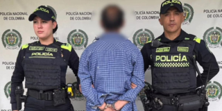 Foto de una persona capturada junto a dos policías