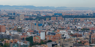 Vista panorámica de Bogotá desde un punto elevado, con numerosos edificios residenciales y comerciales de diferentes alturas que se extienden por la ciudad.