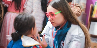 Foto de una doctora maquillando a una niña