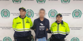Foto de hombre capturado en medio de dos policías.