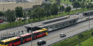 Foto que muestra un bus de TransMilenio y vehículos andando por la calle