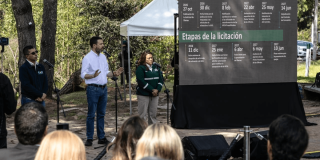 Foto que muestra tres personas hablando por micrófonos 