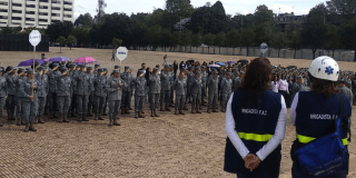 Personal uniformado y equipos de respuesta se reúnen en formación durante un ejercicio de preparación para emergencias en un espacio abierto.