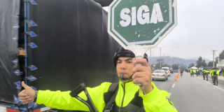 Foto de un militar con un letrero que dice: Siga en color verde 
