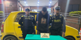 Foto de hombre capturado en medio de dos policías.
