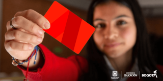 Foto que muestra una mujer sosteniendo una tarjeta en la mano 
