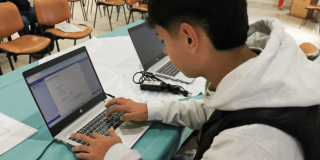 Foto que muestra una persona escribiendo en un computador 