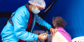 Foto que muestra un enfermero colocando una vacuna en un brazo