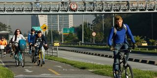 Una avenida y varias personas en cicla movilizandose por esta 
