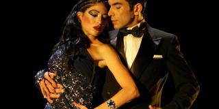 Una pareja de bailarines, se abrazan mientras bailan