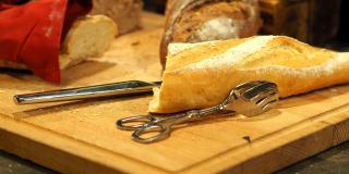 Un pan cortado a la mitad encima de una tabla de cortar 