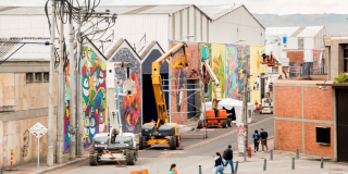 Varias edificios con graffitis, varias personas alrededor