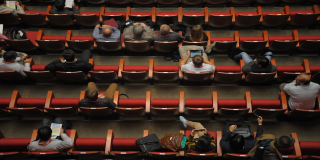 Varias personas sentadas en un auditorio 