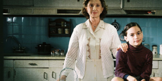 Una mujer mayor sostiene por el hombro a un niño.