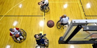 Grupo de personas jugando baloncesto en silla de ruedas.