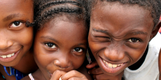 Niños afrodescendientes sonríen a la cámara.