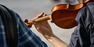 Foto de stock, primer plano de un joven interpretando un violín.