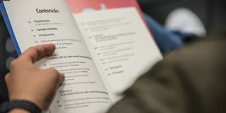 Un hombre sosteniendo un libro 