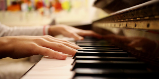 Primer plano de manos tocando el piano.