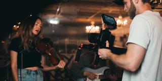 Un hombre grabando a la orquesta en el concierto para cine