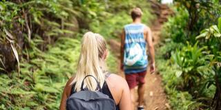 dos personas caminando por un sendero natural 