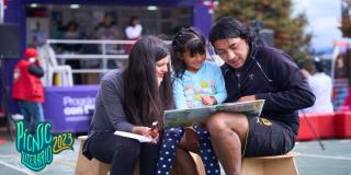 Padre y madre muestran un libro a su hija