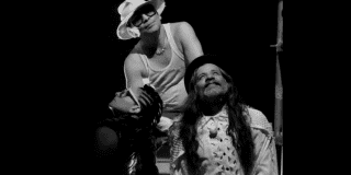 Imagen de dos hombres y una mujer mirando que representan la obra Sin Tierra.