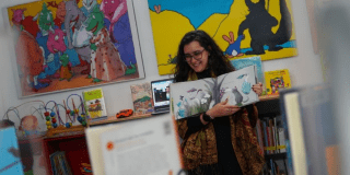 Foto de una mujer mostrando su dibujo. 