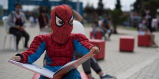Fotografía niño disfrazado de spiderman con un libro abierto