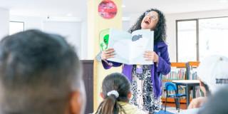 Imagen de una persona con un libro abierto sonriendo