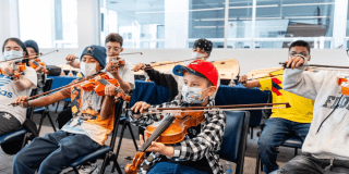 Foto de niños y niñas participan en una clase de violín