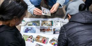 Imagen de personas pegando fotografías en una cartelera blanca
