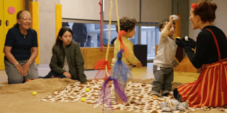 Imagen de varios bebés en taller de trapitud juntos a sus padres y cuidadores