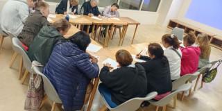 Imagen de varios adultos mayores sentados en un salón participando en la actividad