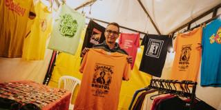 Imagen de persona mostrando camiseta en feria empresarial