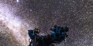 Foto que muestra un proyector y estrellas en el cielo 