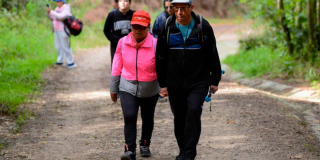 Imagen de varias personas disfrutando de la naturaleza durante una caminata al aire libre.