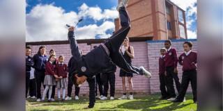 imagen de varios niños viendo como otro baila capoeira.