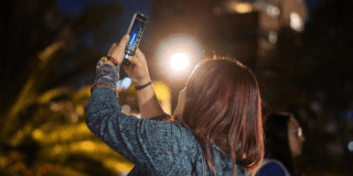 Imagen de mujer tomando foto en caminata nocturna