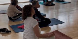 Imagen de variaws personas en clase de yoga.